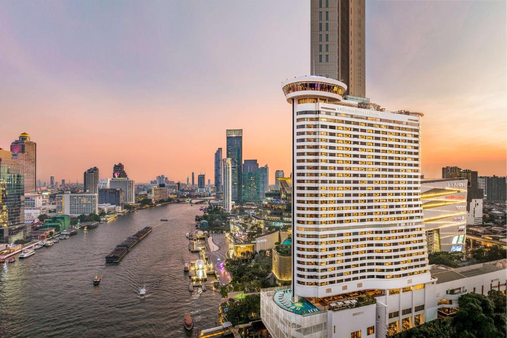 曼谷曼谷千禧希爾頓酒店 的城市里一条河流旁的高楼