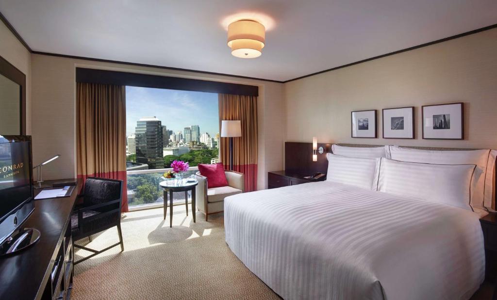 曼谷曼谷港丽公寓酒店的配有一张床、一张书桌和一扇窗户的酒店客房
