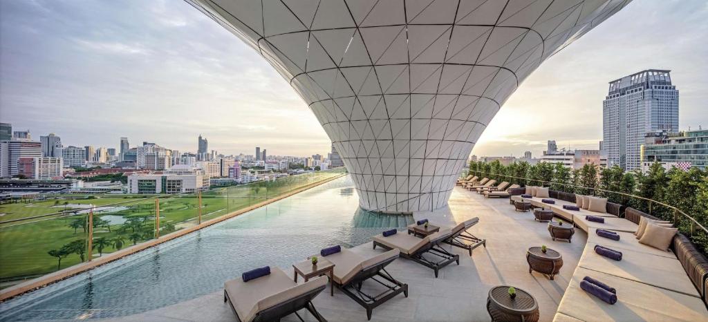曼谷曼谷华尔道夫酒店的从带桌椅的建筑屋顶上欣赏美景
