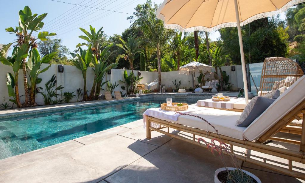 伍德兰希尔斯Cali Luxury Dream Hideaway的别墅 - 带游泳池、床和遮阳伞