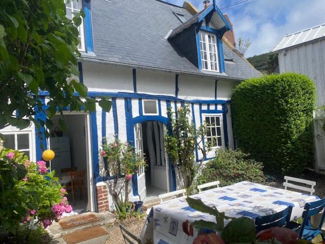 埃特勒塔La Petite Fanny的蓝色和白色的房子,前面有一张桌子