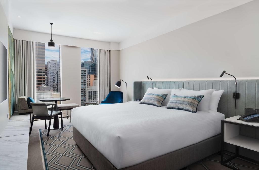 墨尔本Hilton Melbourne Little Queen Street的卧室配有一张白色的大床和一张桌子