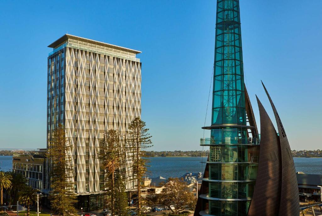 珀斯Doubletree By Hilton Perth Waterfront的一座高大的建筑,毗邻一座大建筑