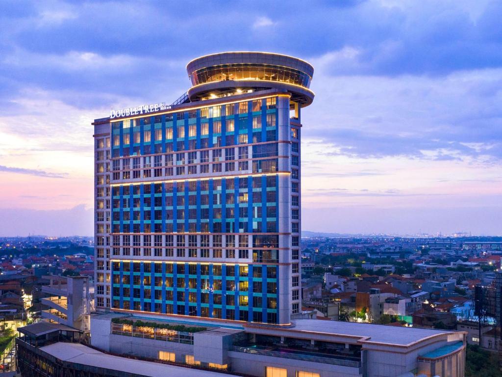 泗水DoubleTree by Hilton Surabaya的一座高大的建筑,上面有灯