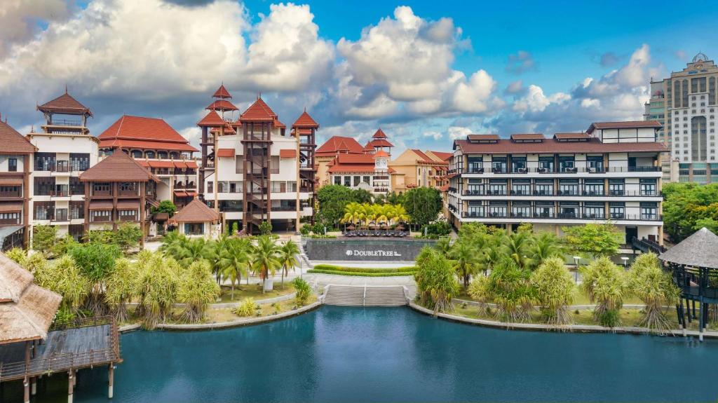 普特拉贾亚DoubleTree by Hilton Putrajaya Lakeside的 ⁇ 染一个拥有河流和建筑物的度假胜地