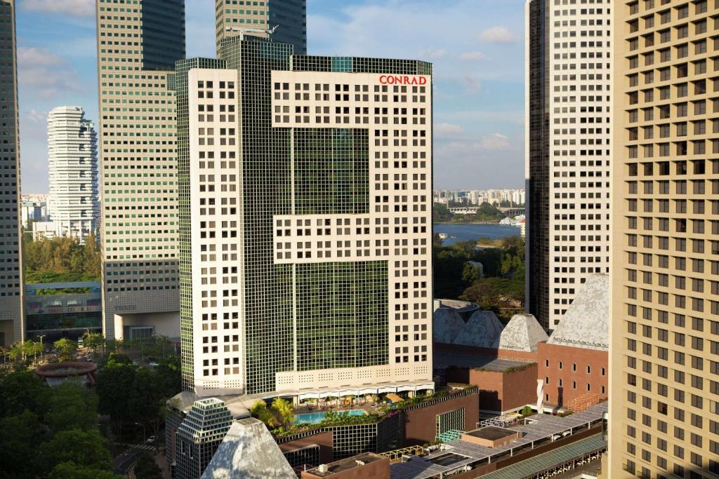 新加坡Conrad Centennial Singapore的一座高大的白色建筑,上面写着字母X