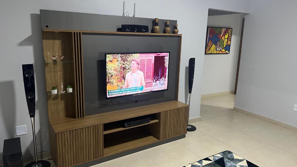 巴西利亚Linda casa em condomínio fechado的木质娱乐中心的平面电视