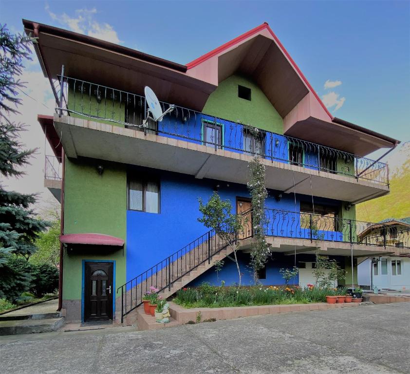 伯伊莱海尔库拉内Casa Aura的蓝色和绿色的建筑设有阳台