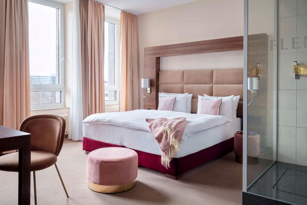 美因河畔法兰克福Flemings Selection Hotel Frankfurt-City的酒店客房带一张大床和一把椅子