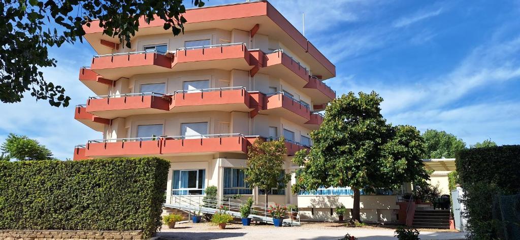 圣费利切-奇尔切奥Hotel Le Pleiadi的建筑的侧面设有红色阳台
