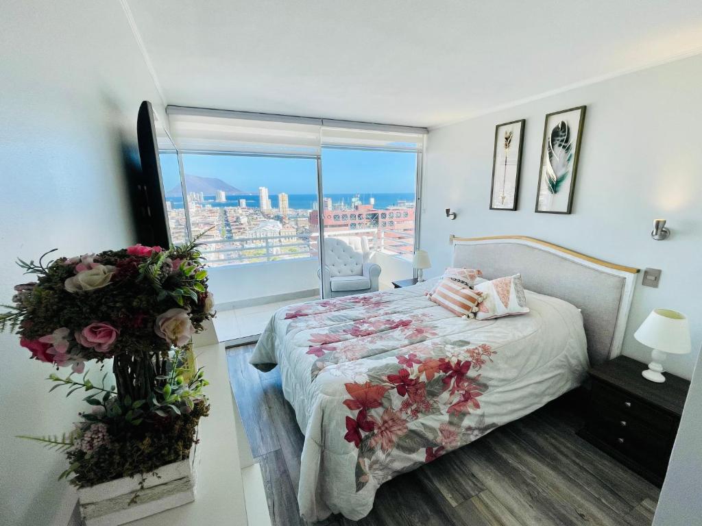 伊基克Departamento con espectacular Ubicación, Vista al Mar y Panorámica a todo Iquique的一间卧室,床上放着鲜花