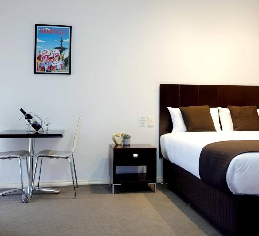 本迪戈金礁汽车旅馆的一间卧室配有一张床、一张桌子和一张书桌