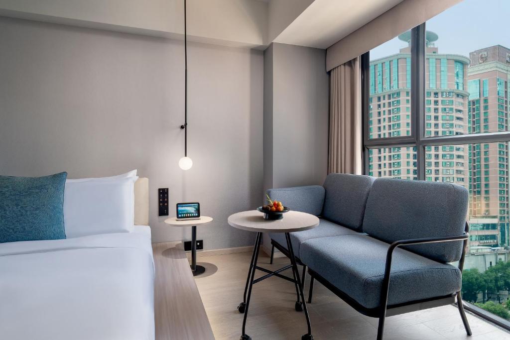 深圳深圳罗湖东门君亭尚品酒店的卧室配有床、椅子和窗户。