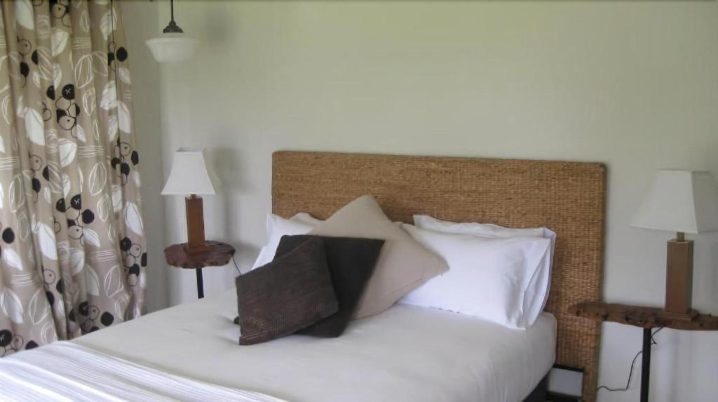 BodallaBodalla Dairy Shed Guest Rooms的一间卧室配有带白色床单和枕头的床。