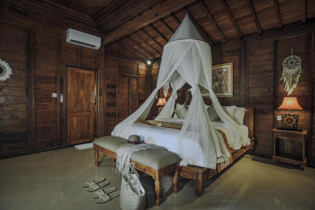 乌布Portobello Villa Ubud的一间卧室配有一张带天蓬的床