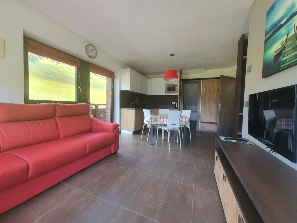 利维尼奥VERDELAGO Appartamenti e CASA CRY的一间带红色沙发的客厅和一间厨房