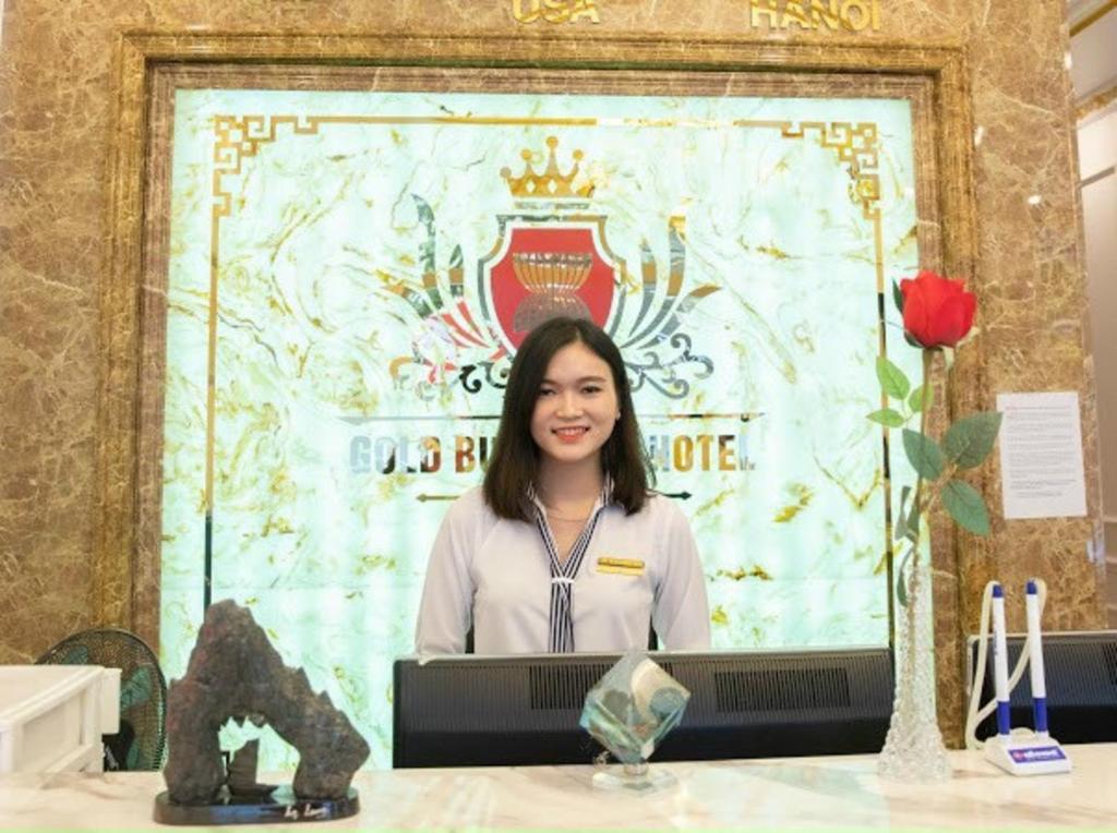 北宁Gold Business Hotel Bắc Ninh的坐在屏幕前桌旁的女人