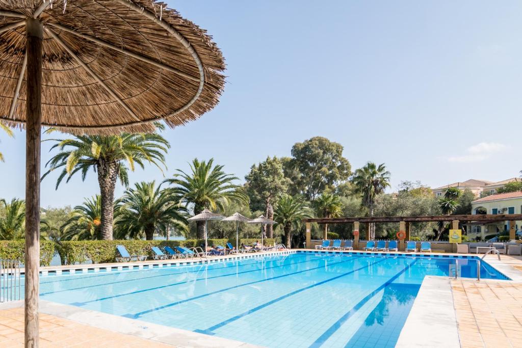 古维亚Helion Resort的一个带遮阳伞和椅子的度假村游泳池