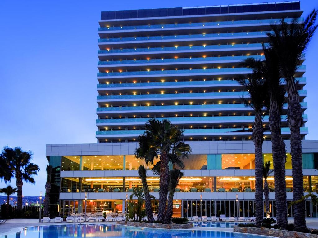 卡尔佩AR Diamante Beach & SPA Hotel 4 SUP的一座棕榈树环绕的大建筑