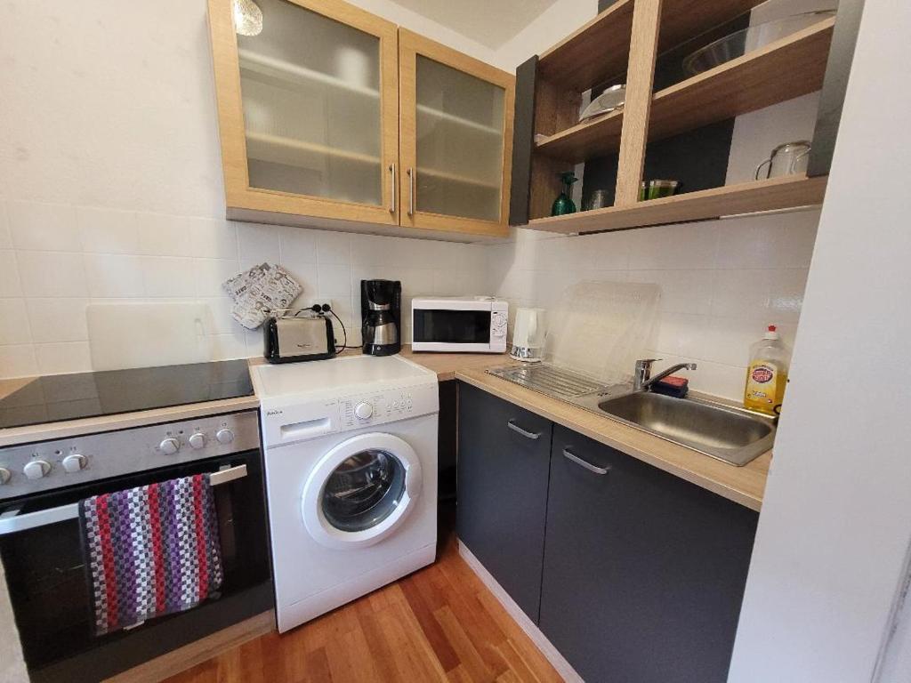 比勒费尔德Marcel's Appartement的厨房配有洗衣机和水槽