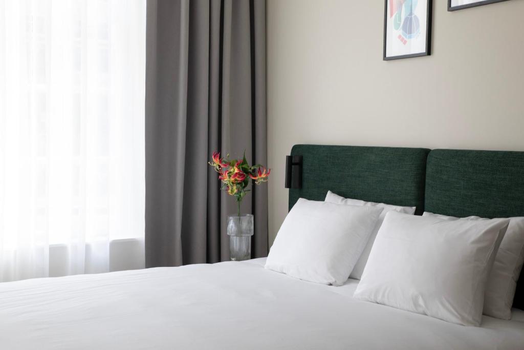 阿姆斯特丹Bob W Oosterpark的卧室配有白色的床和花瓶