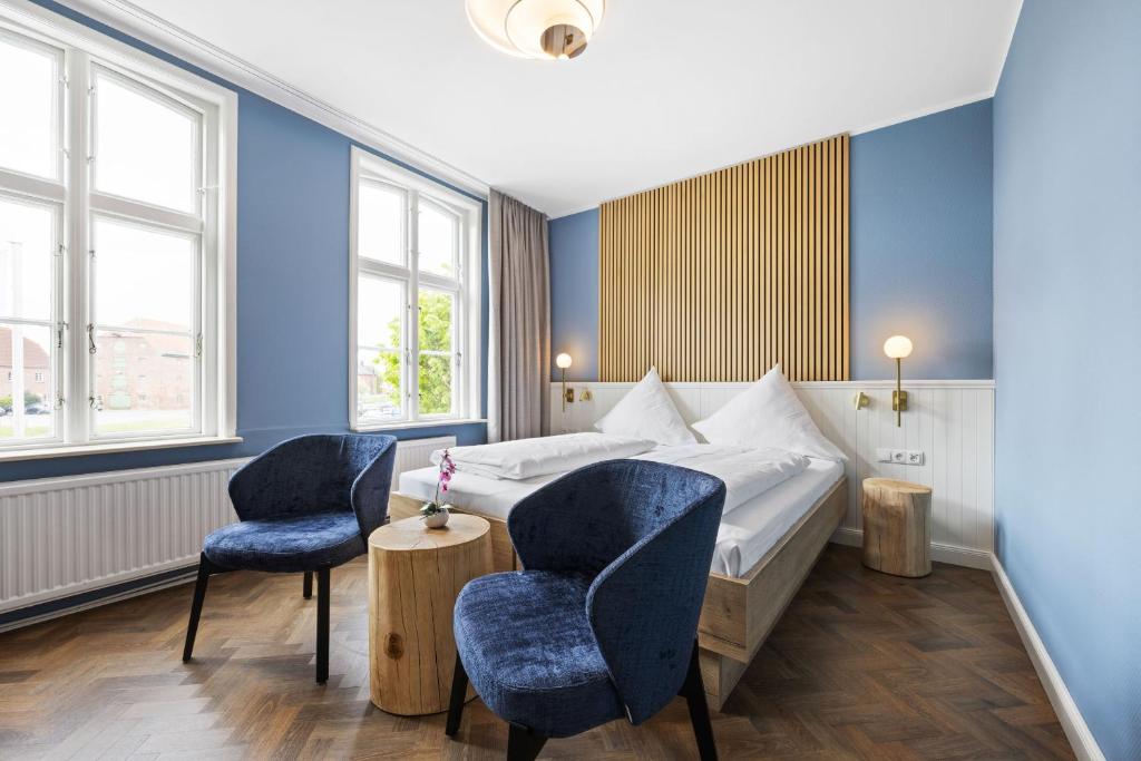 滕宁苏木高登安克尔酒店的酒店客房,配有一张床和两把椅子