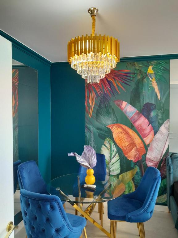 奥拉迪亚Luxury Home的一间带吊灯和蓝色椅子的用餐室