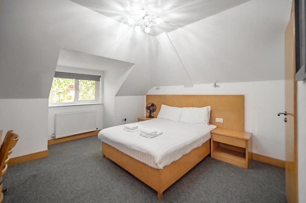 萨顿Flexistay Aparthotel Sutton的一间卧室设有一张大床和一个窗户。
