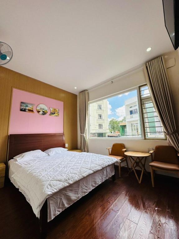 波来古市Bình Minh Motel的一间卧室配有一张床、一张桌子和一个窗户。