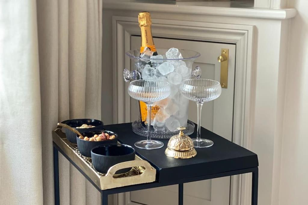 巴斯Luxury Georgian Apartment - 5 Minute Walk to Spa的一张桌子,配有酒杯和一瓶香槟