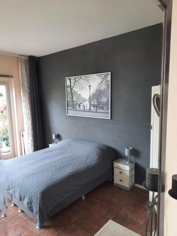 阿姆斯特丹夸伦塔公寓的卧室配有一张床,墙上挂着一幅画