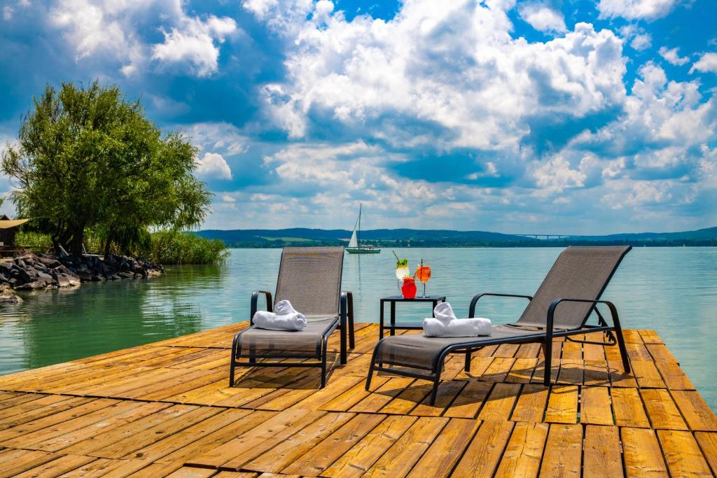 蒂豪尼Tihany Yacht Club的两把椅子坐在水面上的码头上