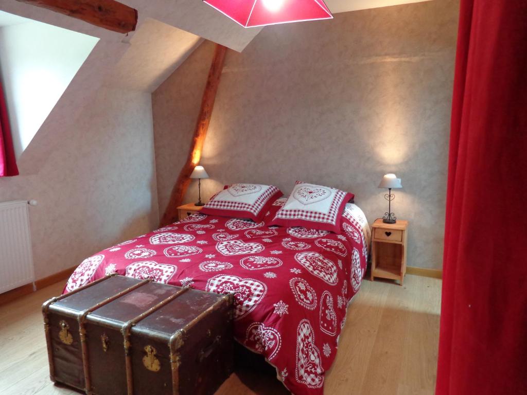 康庞La Boucle de l'Adour Chambres d'Hôtes & gîtes的一间卧室配有一张带红色毯子和毛巾的床