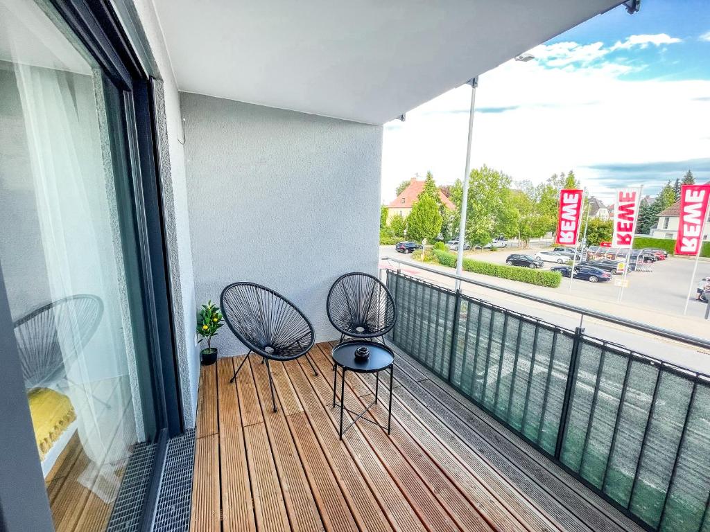 梅明根theSunset Club - STUDIO Küche - Balkon - Parken的街景阳台的两把椅子