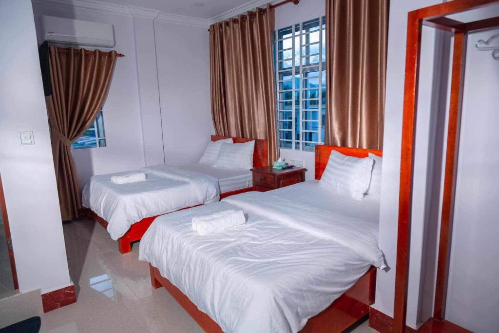 贡布Kim Chua Guest House的带窗户的客房内的两张床