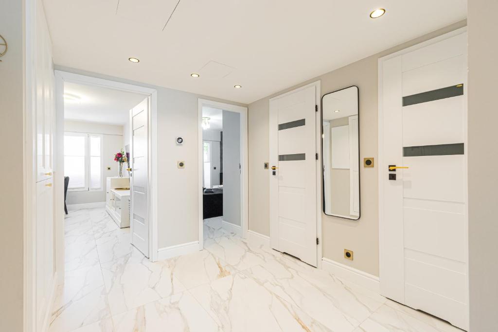 昂蒂布St George的走廊设有白色墙壁、白色地板和镜子