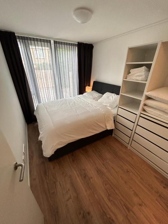 诺德韦克Noordwijk BB228的一间卧室设有一张床和一个大窗户