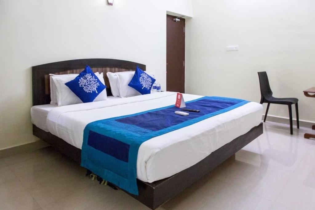钦奈AN STAYS Chennai Airport的一间卧室配有一张带蓝白色枕头的大床