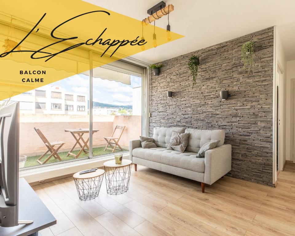 沙马列尔L'Echappée的带沙发和砖墙的客厅