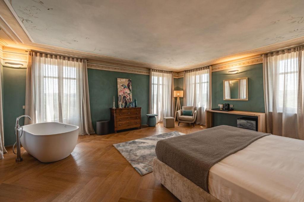 科斯蒂廖莱达斯蒂Monvì Wine Relais的一间卧室设有一张大床和一个浴缸