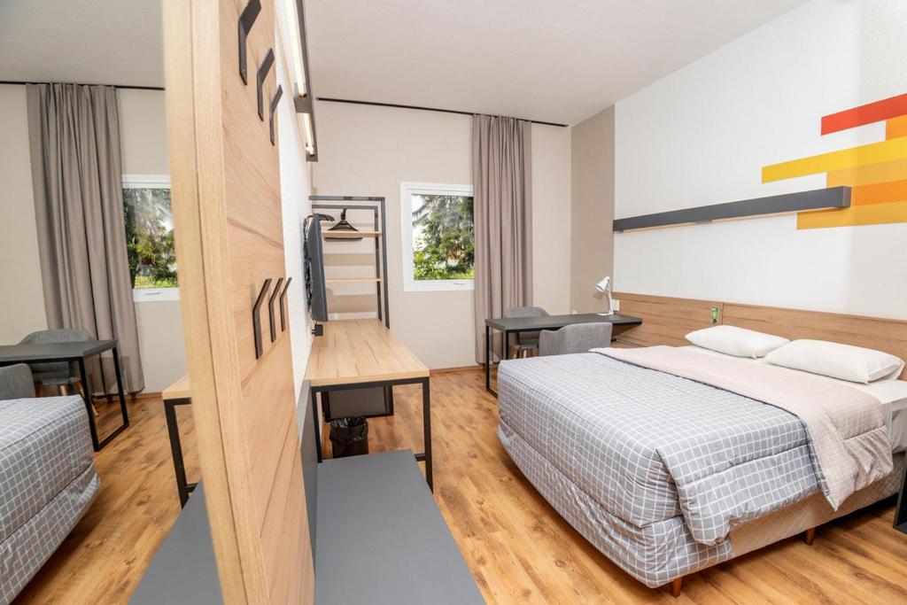 伊达贾伊伊塔耶埃/纳维根特斯十号酒店的酒店客房配有一张床、一张书桌和一张四柱床