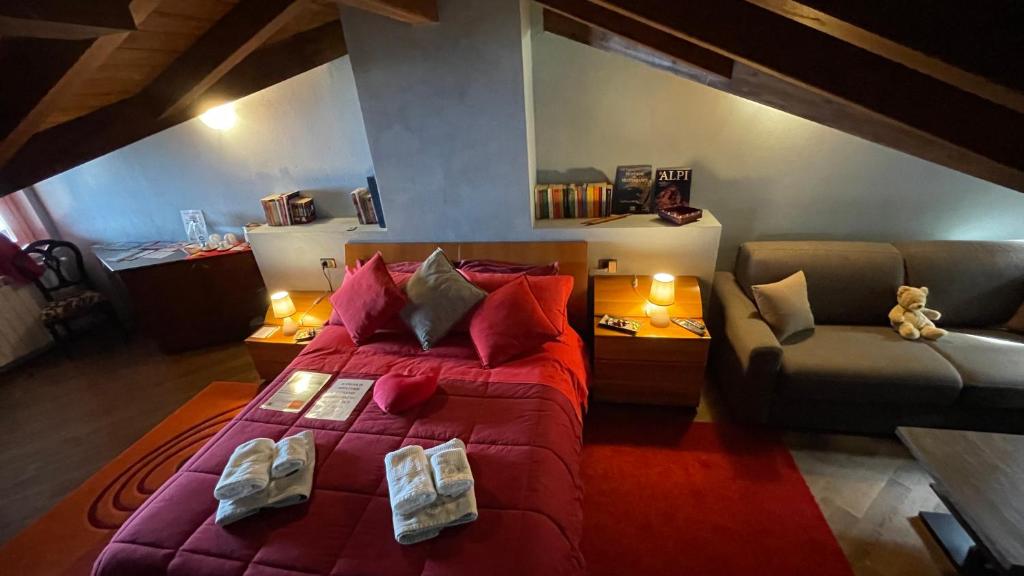 斯特雷萨Alba sul lago B&B的一间卧室配有一张红色的大床和一张沙发