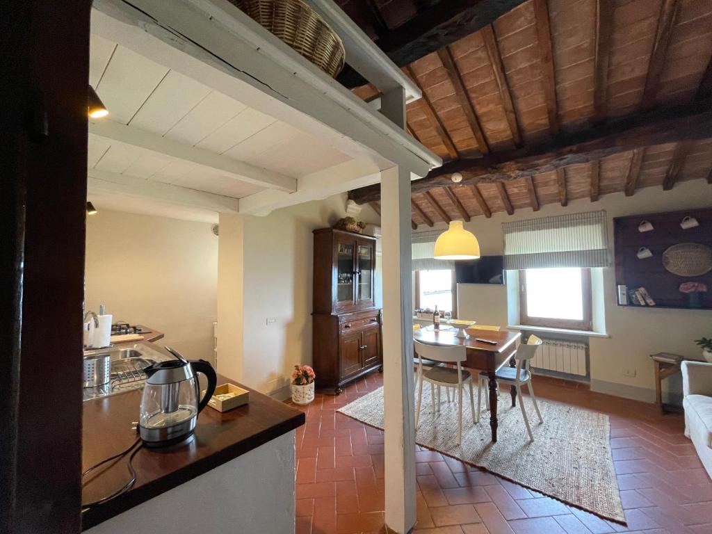 蒙特普齐亚诺Appartamento centro storico La Pulcianella的厨房以及带桌椅的起居室。
