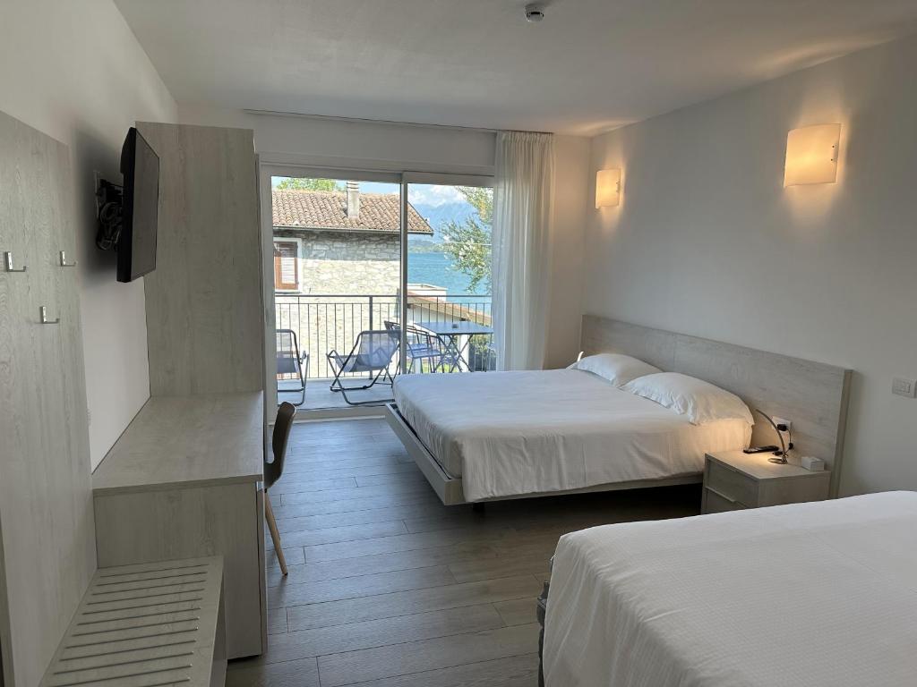 多马索Resort le Vele Suites and Apartments的酒店客房设有两张床和一个阳台。