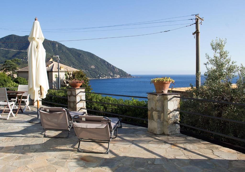 卡莫利La CONCHIGLIA Bed & Breakfast的一个带椅子和遮阳伞的庭院和大海