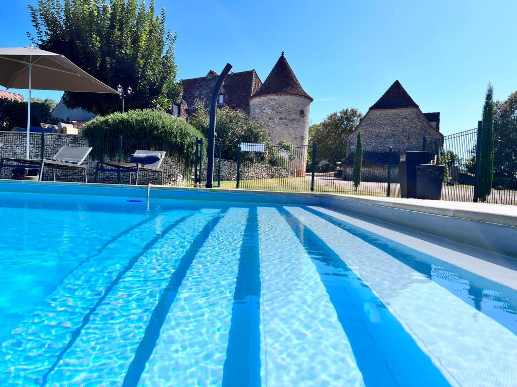 罗卡马杜尔Hôtel Les Vieilles Tours Rocamadour的房屋前的游泳池