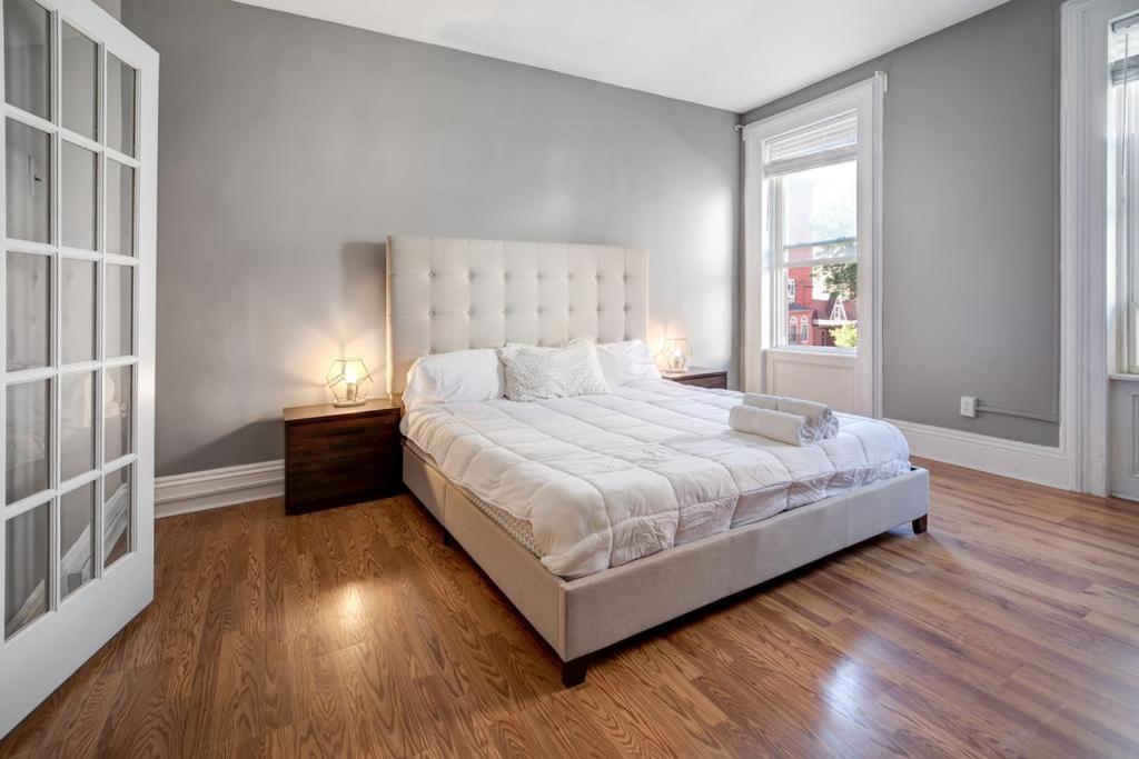 霍博肯Get Spoiled in this Urban 1BR 15min to NYC的白色卧室设有一张大床和两个窗户