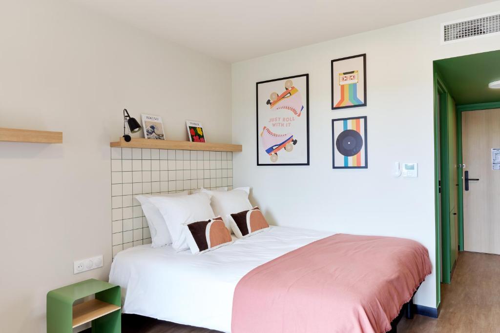 拉贝格Hife Toulouse Labège的卧室配有带粉红色床单的大型白色床