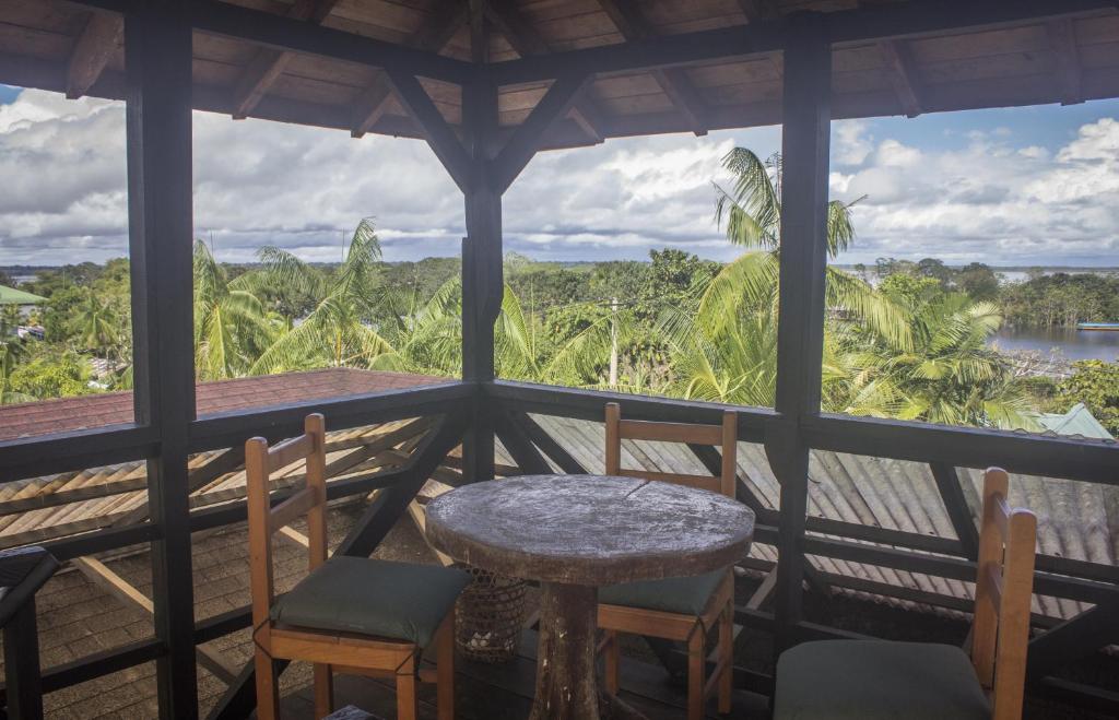 Puerto NariñoWaira Selva Hotel的美景门廊上的桌椅