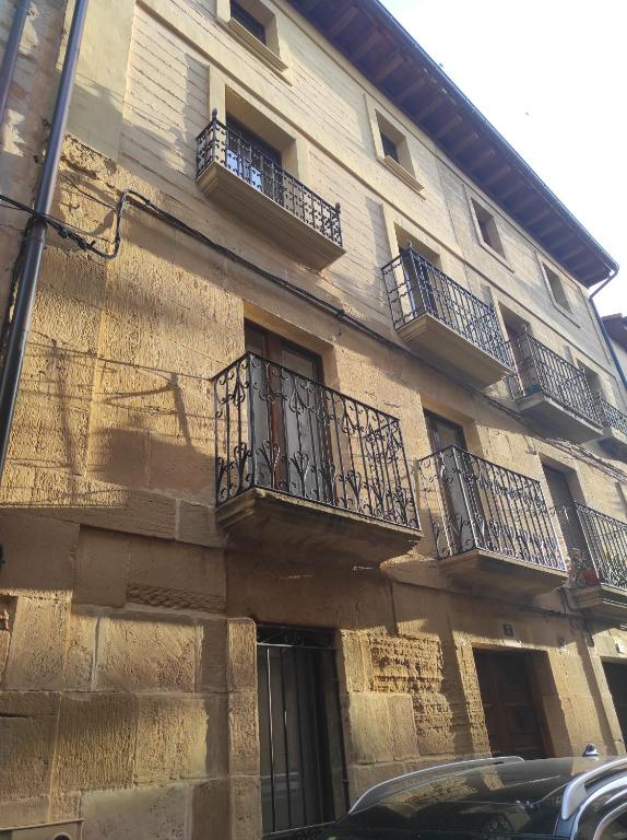 布里奥内斯Casa Moneo的带阳台的建筑,前面设有停车场